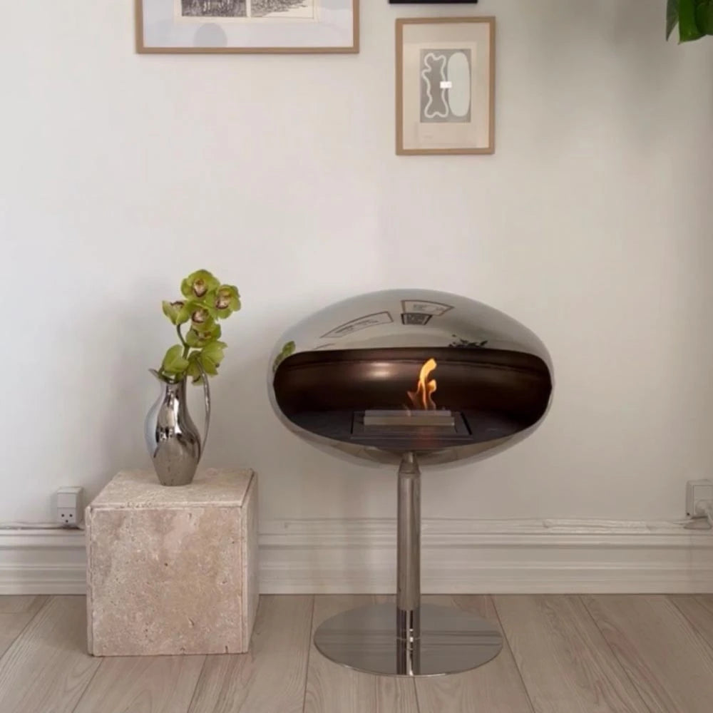 Imaginez la lueur chaleureuse du Cocoon Pedestal en acier poli, illuminant vos soirées avec élégance.